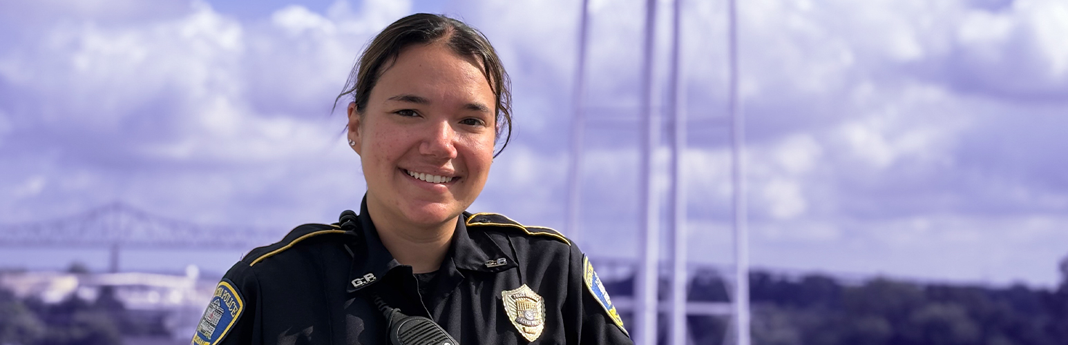 GPD Officer posing in front of the Gretna water tower in downtown Gretna. The background of the image has a blue tint to it.